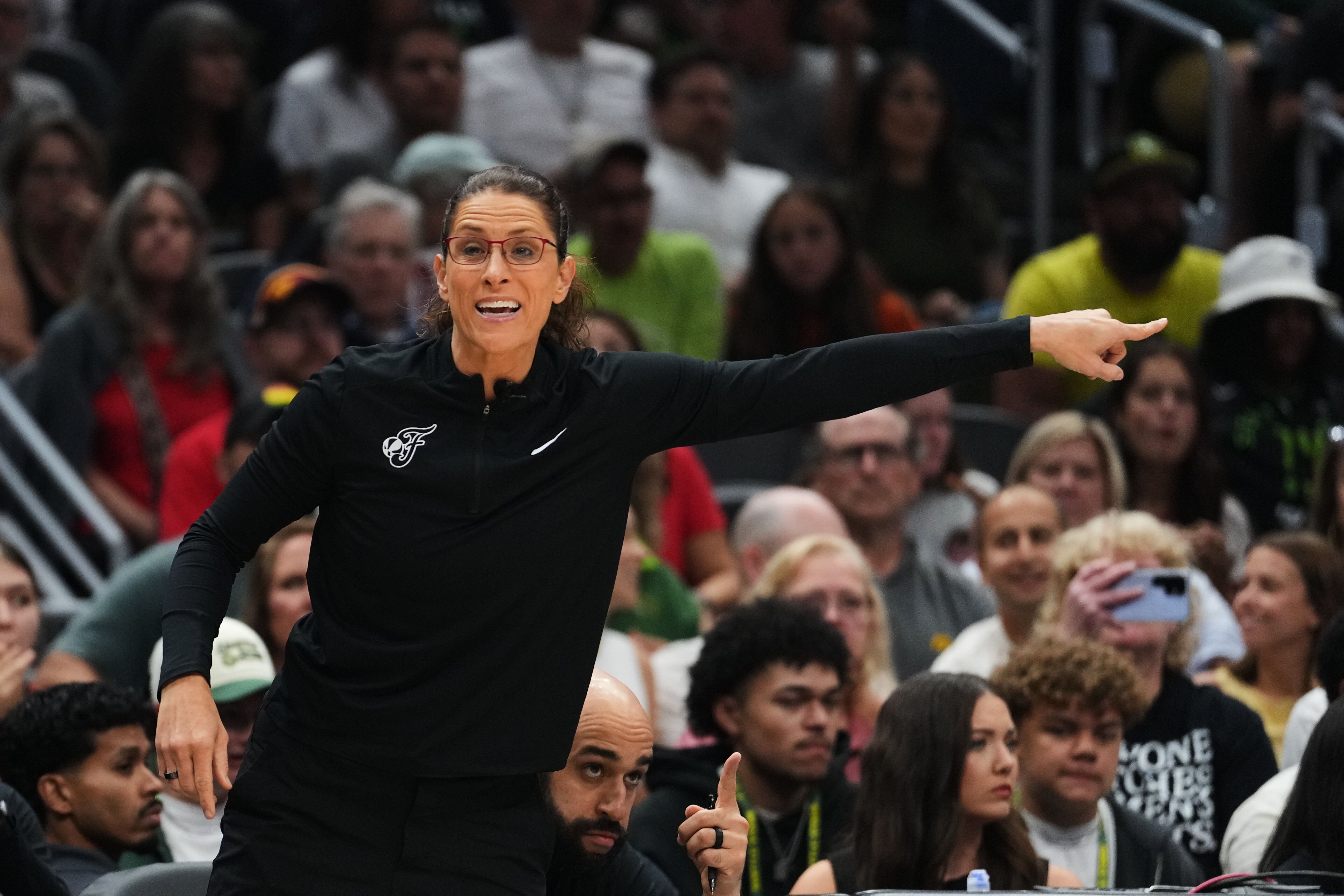 Sophie Cunningham of Indiana Fever seen running by fan with sign referencing her comments on transgender athletes during WNBA game against Seattle Storm