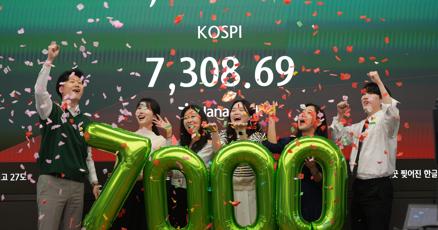 Employees of Hana Bank celebrate in a photo opportunity to mark the Korea Composite Stock Price Index (KOSPI) of over 7,000 points at a dealing room of Hana Bank in Seoul, South Ko