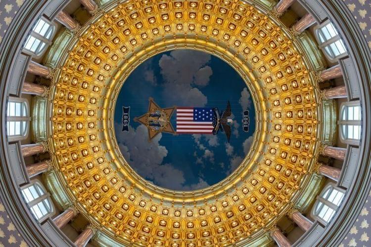 A larger-than-life-size replica of a Grand Army of the Republic badge hangs just below the ceiling of the Iowa Capitol's rotunda, one of many Civil War-related artworks, monuments and artifacts in the building, construction of which began six years afte...