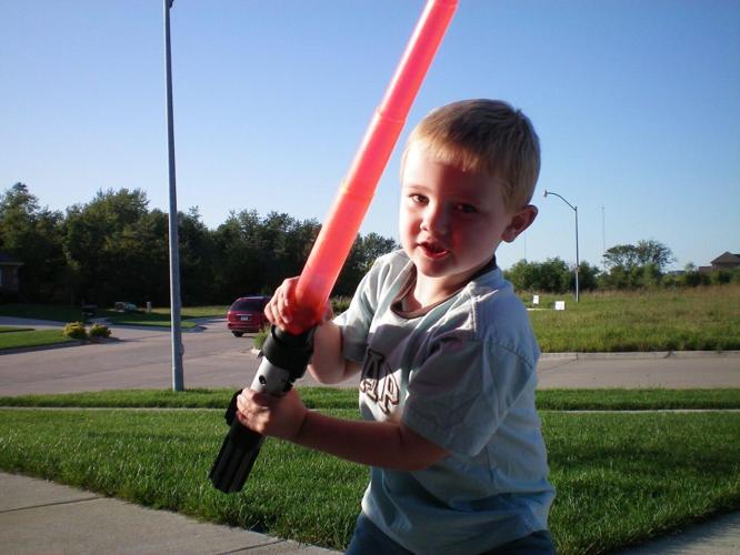 Carson DeJoode waves a lightsaber