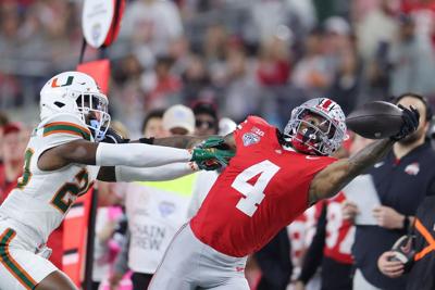 Ohio State's Jeremiah Smith attempts a catch in front of Miami's OJ Frederique Jr. in the second quarter of a College Football Playoff quarterfinal at the 90th Goodyear Cotton Bowl Classic at AT&T Stadium on Dec. 31, 2025, in Arlington, Texas.