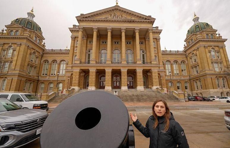 Iowa State Capitol legislative information officer Kelsie Willert speaks about a Civil War mortar on display outside of the Iowa Capitol.