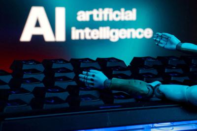 FILE PHOTO: Illustration shows message reading "AI artificial intelligence", keyboard and robot hands