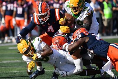 Oregon  running back Dierre Hill Jr., left, is brought down by the Illinois defense during the first half at Gies Memorial Stadium in Champaign, Illinois on Oct. 24, 2026.
