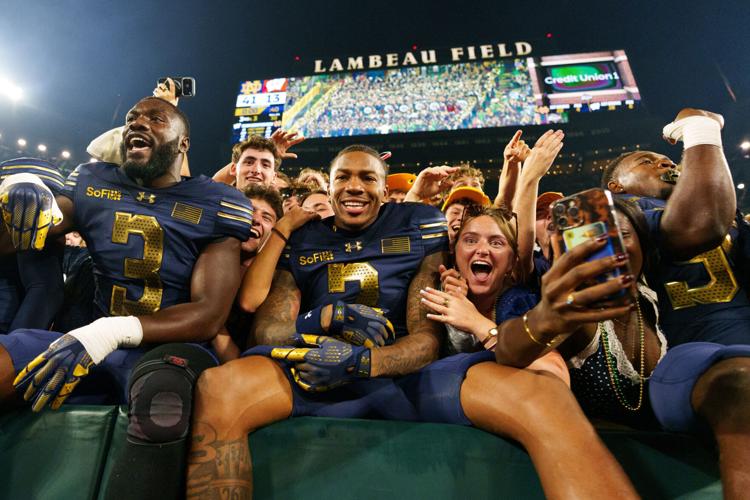 Notre Dame celebrates with the student section after winning a NCAA football game 41-13 against Wisconsin at Lambeau Field on