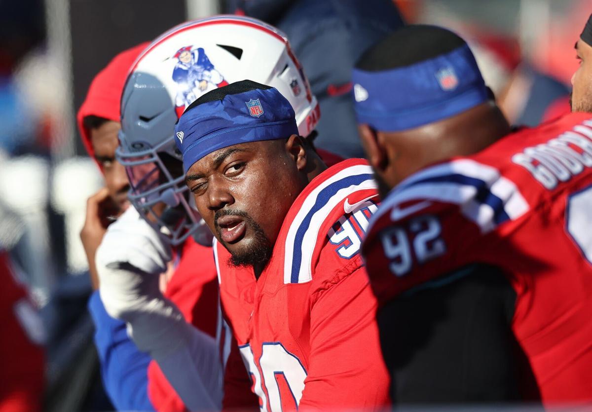New England Patriots defensive lineman Christian Barmore looks at Davon Godchaux on the bench after the defense gave up a touchdown during a game at Gillette Stadium last season.