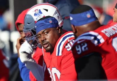 New England Patriots defensive lineman Christian Barmore looks at Davon Godchaux on the bench after the defense gave up a touchdown during a game at Gillette Stadium last season.