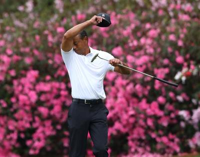 Tiger Woods wipes his face, taking a momentary break on the 13th green during his practice round for the Masters at Augusta National Golf Club on Wednesday, April 6, 2022, in Augusta, Georgia.