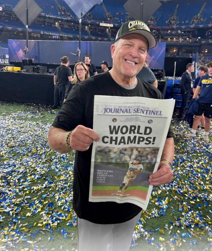 Milwaukee Brewers manager Pat Murphy holds up a Milwaukee Journal Sentinel  “World Champs” newspaper while celebrating  after