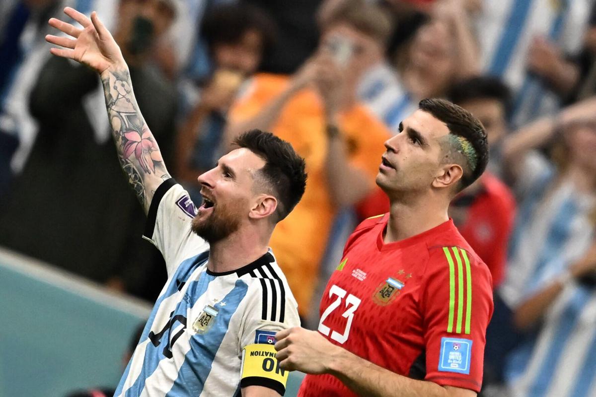 Argentina's forward Lionel Messi and Argentina's goalkeeper Emiliano Martinez celebrate with the crowd after qualifying for the next round after defeating the Netherlands in the penalty shoot-out of the Qatar 2022 World Cup quarter-final football match ...