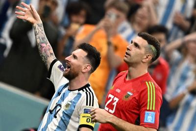 Argentina's forward Lionel Messi and Argentina's goalkeeper Emiliano Martinez celebrate with the crowd after qualifying for the next round after defeating the Netherlands in the penalty shoot-out of the Qatar 2022 World Cup quarter-final football match ...