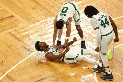 The Boston Celtics' Marcus Smart reacts to a play with teammates Jayson Tatum and Robert Williams III in the fourth quarter against the Golden State Warriors during Game 3 of the NBA Finals at TD Garden on Wednesday, June 8, 2022, in Boston.