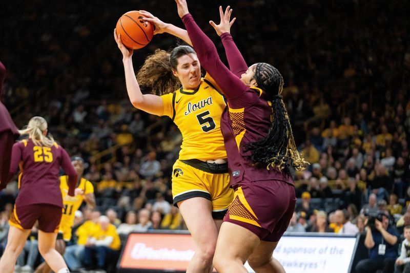 Iowa center Ava Heiden (5) keeps possession of the ball against Minnesota forward Finau Tonga (31) on Feb. 5, 2026, at Carver-Hawkeye Arena.