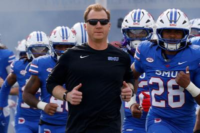 SMU head coach Rhett Lashlee and players run onto the field before an NCAA college football game against Louisville at Gerald J. Ford Stadium, Saturday, Nov. 22, 2025, in University Park, Texas.