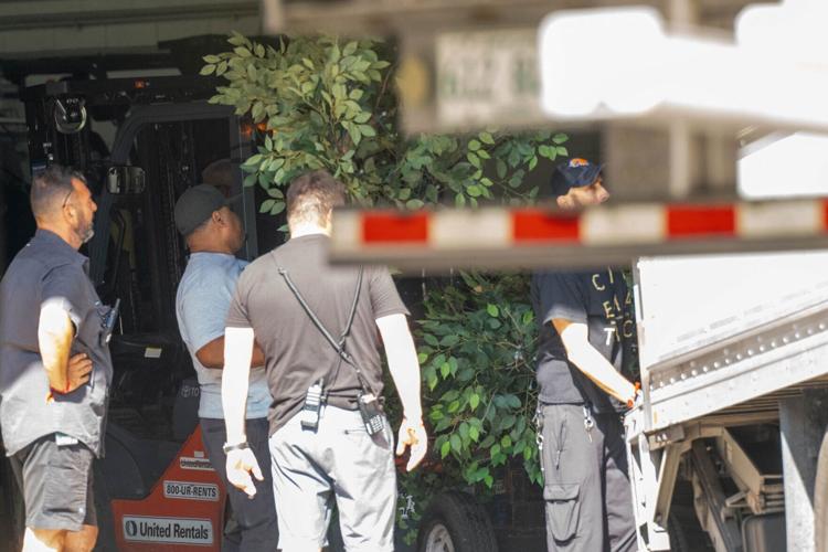 Foliage is unloaded at Madison Square Garden, as trucks are used to attempt to block media from seeing, in New York City