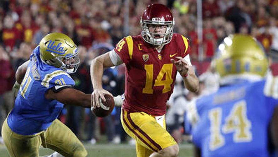USC's Sam Darnold, middle, scrambles out of the pocket and away from UCLA defensive lineman Jacob Tuioti-Mariner, left, during the quarterback's time with the Trojans.