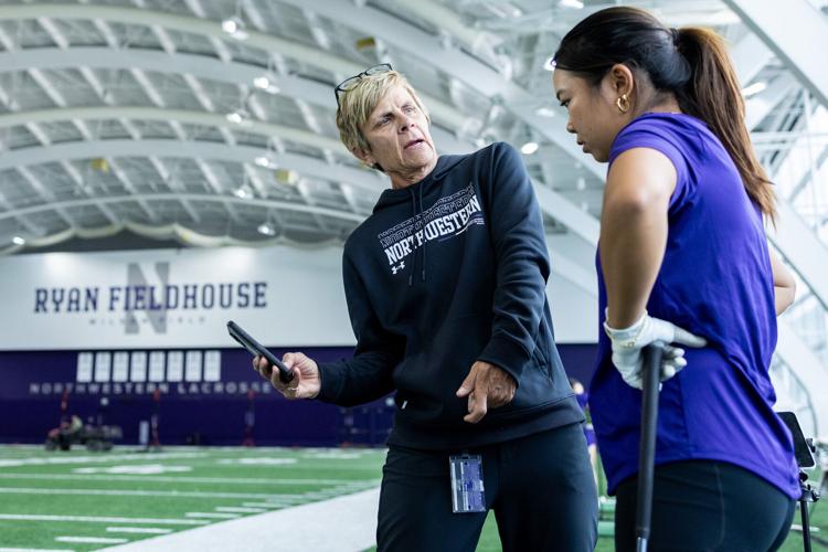 Head coach Emily Fletcher, left, shows Megan Meng how to change her swinging stance during a Northwestern women’ s golf practice at Ryan Fieldhouse in Evanston, Illinois, on Friday, Feb. 20, 2026.