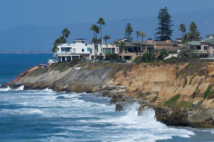 Waves collide with the bluffs during high tide in Carlsbad