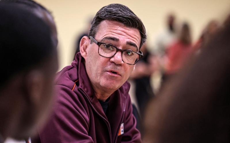 Britain's Prime Minister Andy Burnham talks with staff during a visit to a Sainsbury’s store