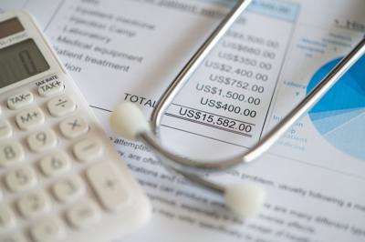 Plan for medical expenses concept. Medical treatment expense on bill statement with calculator and stethoscope.