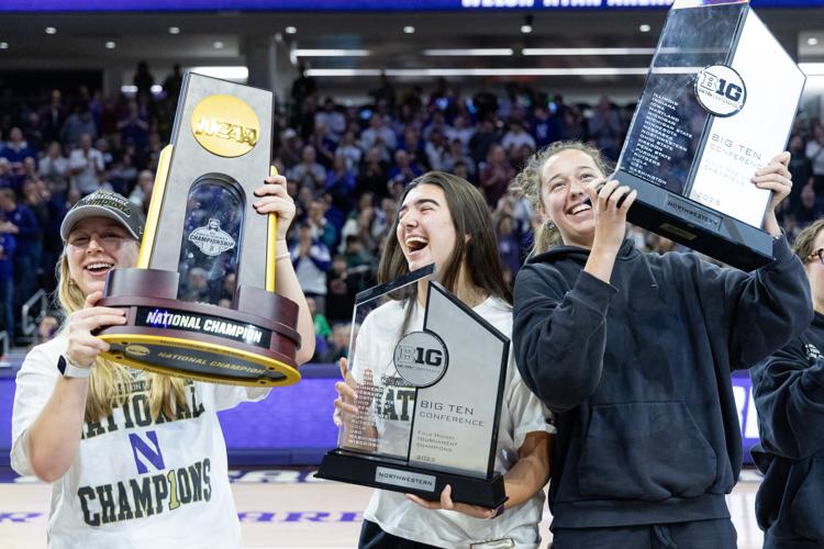 Northwestern field hockey midfielder Greta Hinke, from left, fullback Maja Zivojnovic and goalkeeper Juliana Boon celebrate with the Big Ten and NCAA championship trophies during a men’ s basketball game against Oregon on Feb. 28, 2026, at Welsh- Ryan A...
