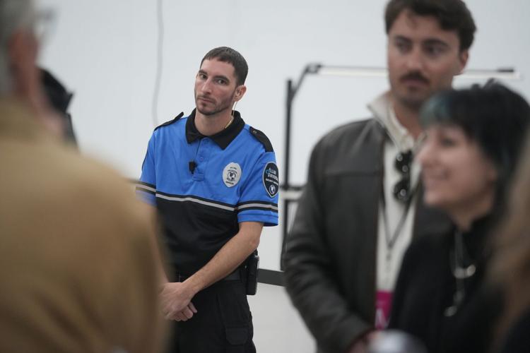 A security guard keeps an eye on a media tour at the Anduril Arsenal-1 drone production facility outside Columbus, Ohio, on March 19, 2026.