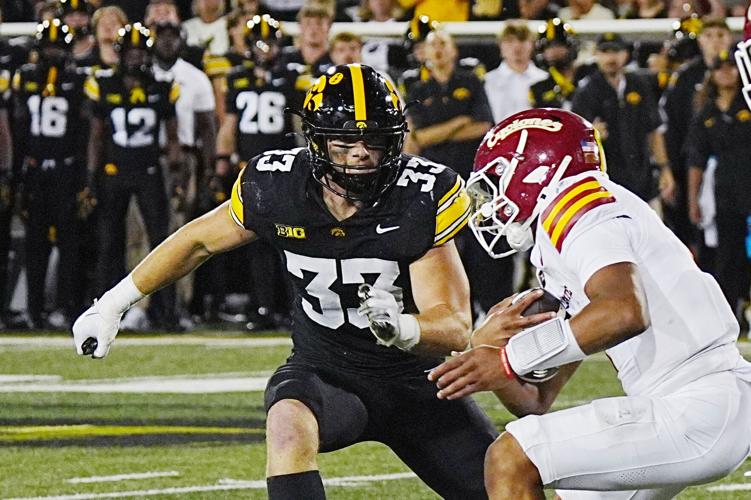 Iowa State quarterback Jaylen Raynor (1) battle for extra yard as getting tackle by Iowa Hawkeyes linebacker Cam Buffington (33)