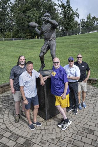 From left, West Chester University football alumni Tom Weaver, Mike Esposito, Bob Campbell, Mike Hudson and Dean DiPasquale pose for a photo with a statue honoring their former teammate Michael Horrocks on Aug. 17, 2026, in Chester County, Pennsylvania.