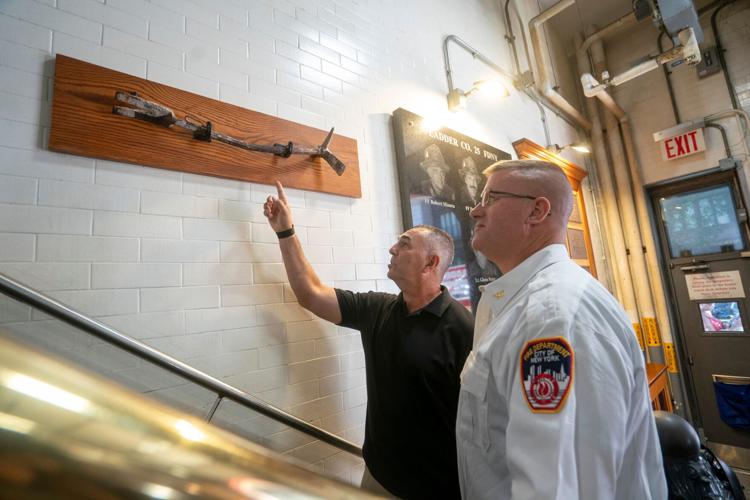 Retired New York Mets player John Franco looks at a tool used during Sept. 11, 2001 with a firefighter during an annual event