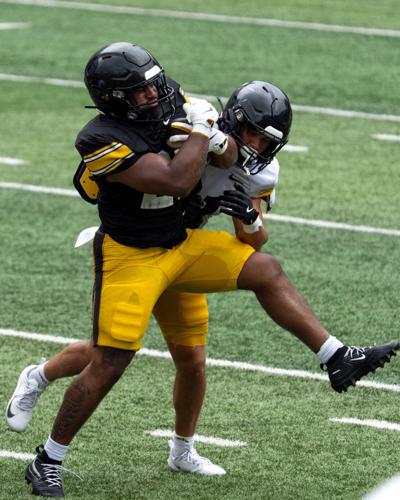 Iowa running back L.J. Phillips Jr. (21) is tackled by Iowa defensive back Marcello Vitti (21) while carrying the ball Aug. 15,