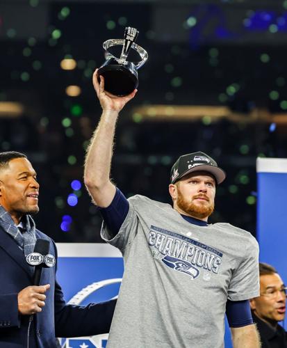 Seattle Seahawks quarterback Sam Darnold raises the trophy alongside Michael Strahan after a 31-27 win over the Los Angeles Rams in the NFC Championship on Jan. 25, 2026, at Lumen Field in Seattle.