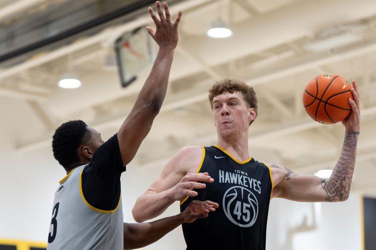 Iowa center Andrew McKeever passes the ball around Cam Manyawu during a summer basketball practice July 8, 2026 at