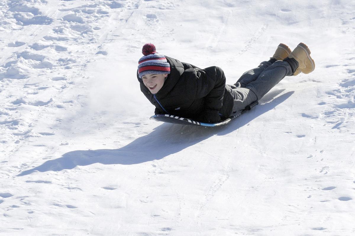 Corbin Cresta, 14, of Derry slides headfirst down the sledding hill during the 17th annual Frost Festival activities at Alexander Carr Park.
