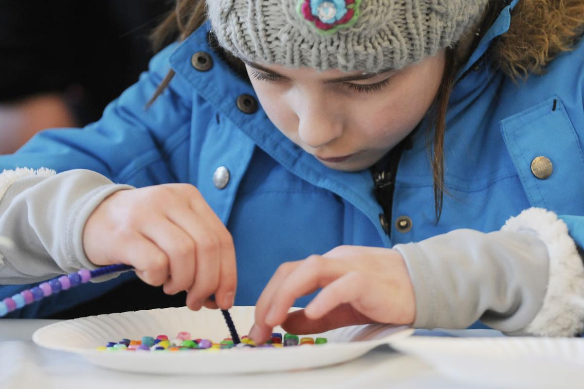 Loralei Wales, 10, of Derry puts a bracelet together in the craft area during the 17th annual Frost Festival activities at Alexander Carr Park.
