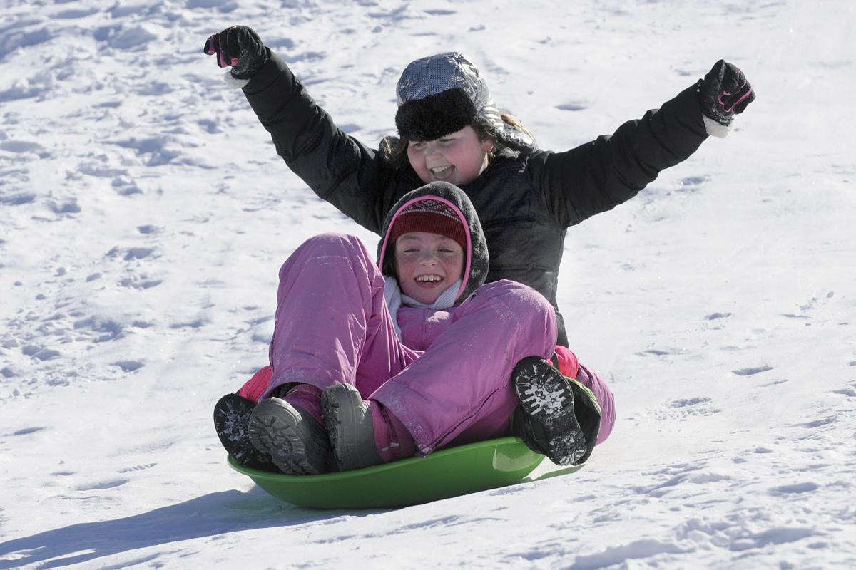 Katherine Norcross, 9, in front, and her friend Audrey Couture, 10, both of Derry, have fun coming down the sledding hill during the 17th annual Frost Festival activities at Alexander Carr Park.
