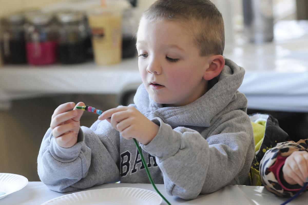 Jayden Pereira, 5, of Derry puts a bracelet together in the craft area during the 17th annual Frost Festival activities at Alexander Carr Park.