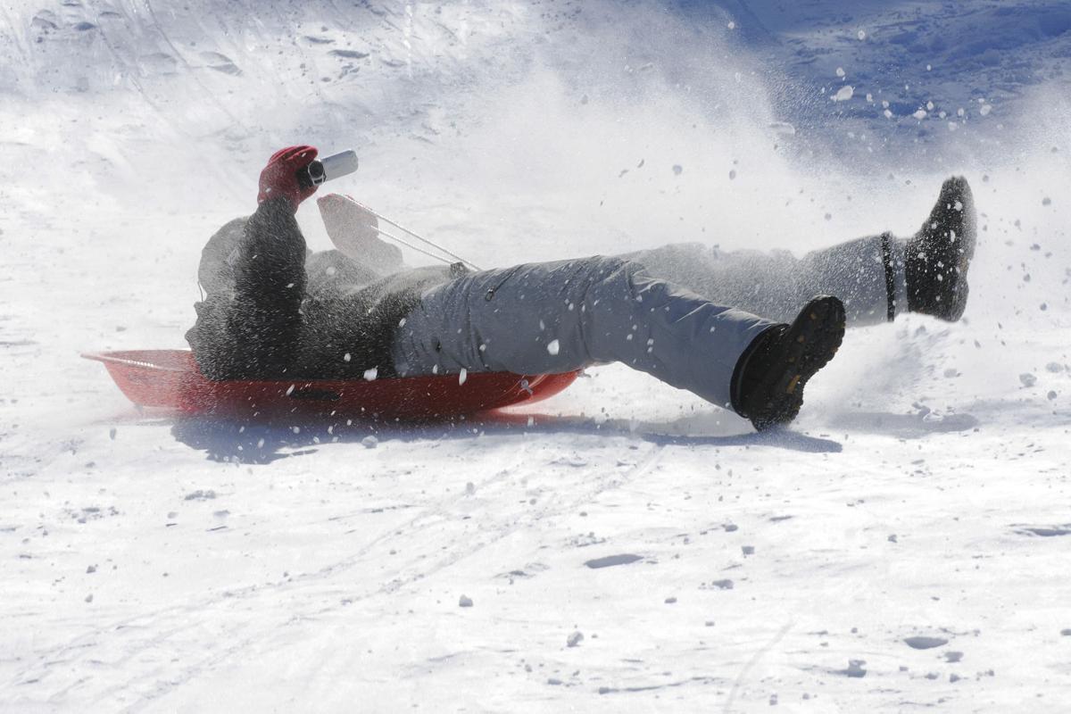 Brendan Parisr, 20, of Derry tries to shoot video while he comes down the sledding hill during the 17th annual Frost Festival activities at Alexander Carr Park.