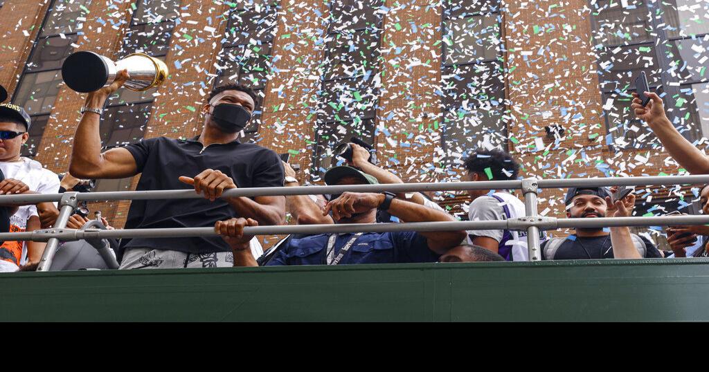 Milwaukee Bucks' Giannis Antetokounmpo holds up the NBA Championship trophy  and Finals MVP trophy to the crowd during a parade celebrating the  Milwaukee Bucks' NBA Championship basketball team Thursday, July 22, 2021
