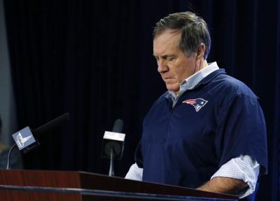 New England Patriots head coach Bill Belichick reads from notes as he speaks during a news conference prior to a team practice in Foxborough Thursday, Jan. 22. Belichick addressed the issue of the NFL investigation of deflated footballs.