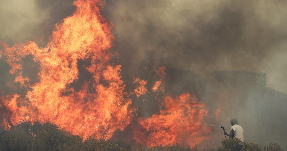Homeowner Steven Phelps battles the Pinehaven Fire in the Caughlin Ranch area of Reno on Nov. 17, 2020.