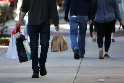 People shop for holiday gifts along Park Avenue in Winter Park, on Dec. 23, 2021.