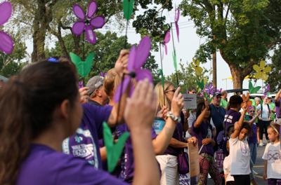 Participants hold up pinwheel flowers