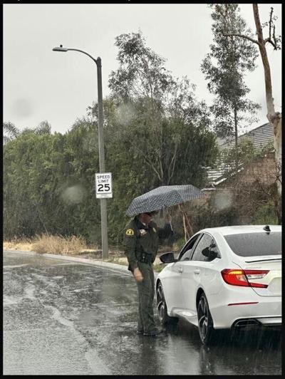 Polite motorist gives officer an umbrella to use during traffic stop in