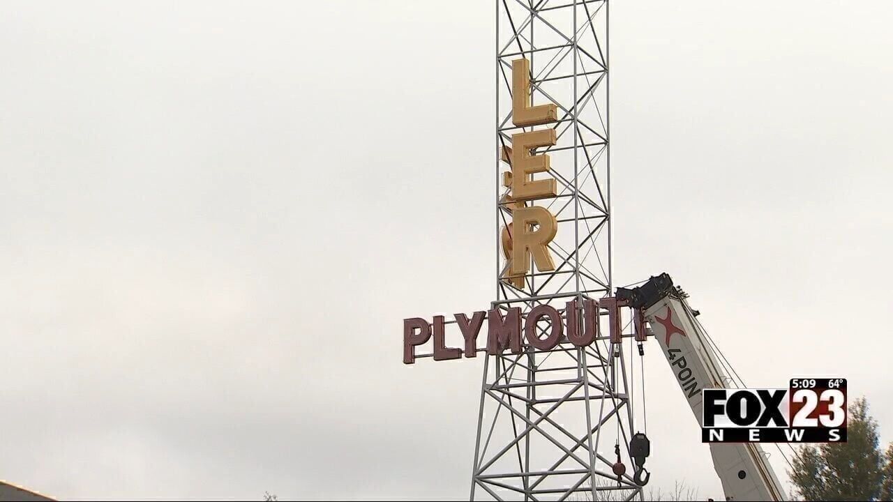 Crews begin installing neon lettering on Chrysler-Plymouth Tower