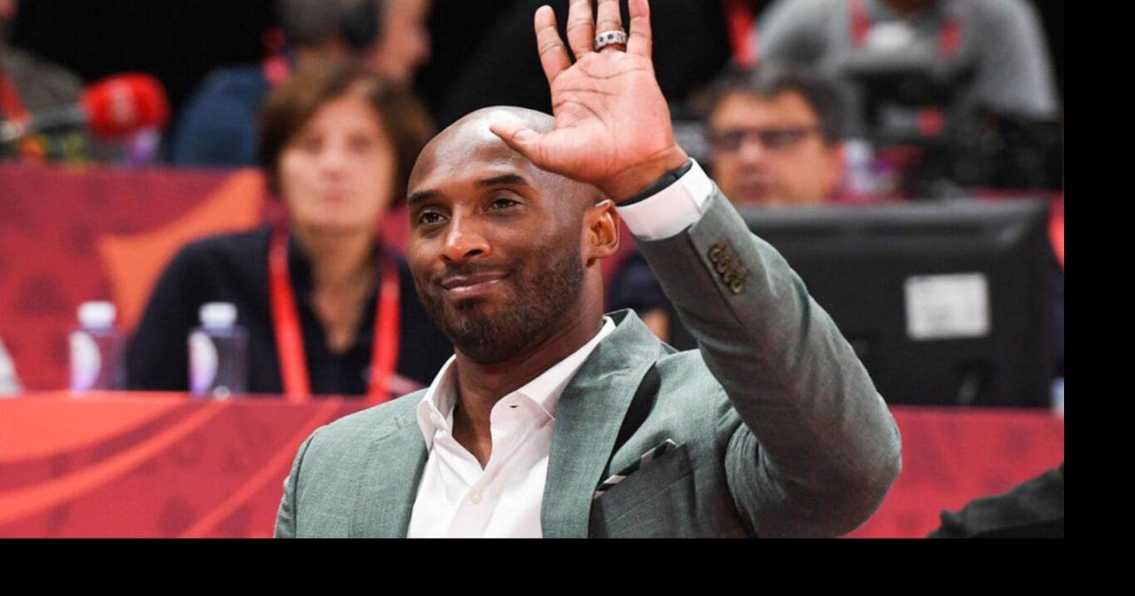 Former Laker Kobe Bryant waves to the crowd during his jersey
