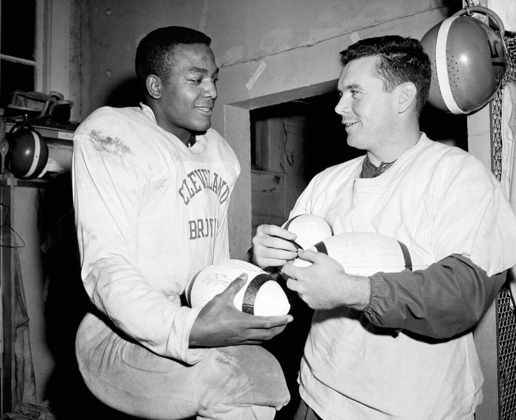 FILE - In this October 1960 file photo, Cleveland Browns fullback Jim Brown  (32) runs with a reception as Dallas Cowboys' Tom Franckhauser (32) defends  and Don Healy falls to the turf