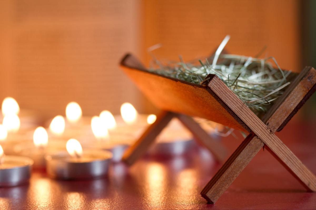 Manger nativity scene candles and bible in night