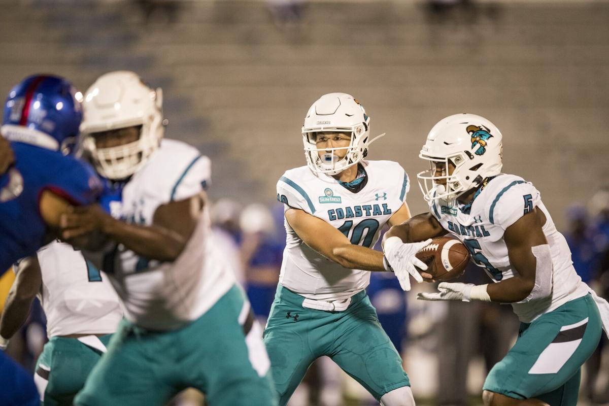 Quarterback Grayson McCall of the Coastal Carolina Chanticleers hands the ball off to running back Shermari Jones at Memorial Stadium on Sept. 12, 2020 in Lawrence, Kansas.