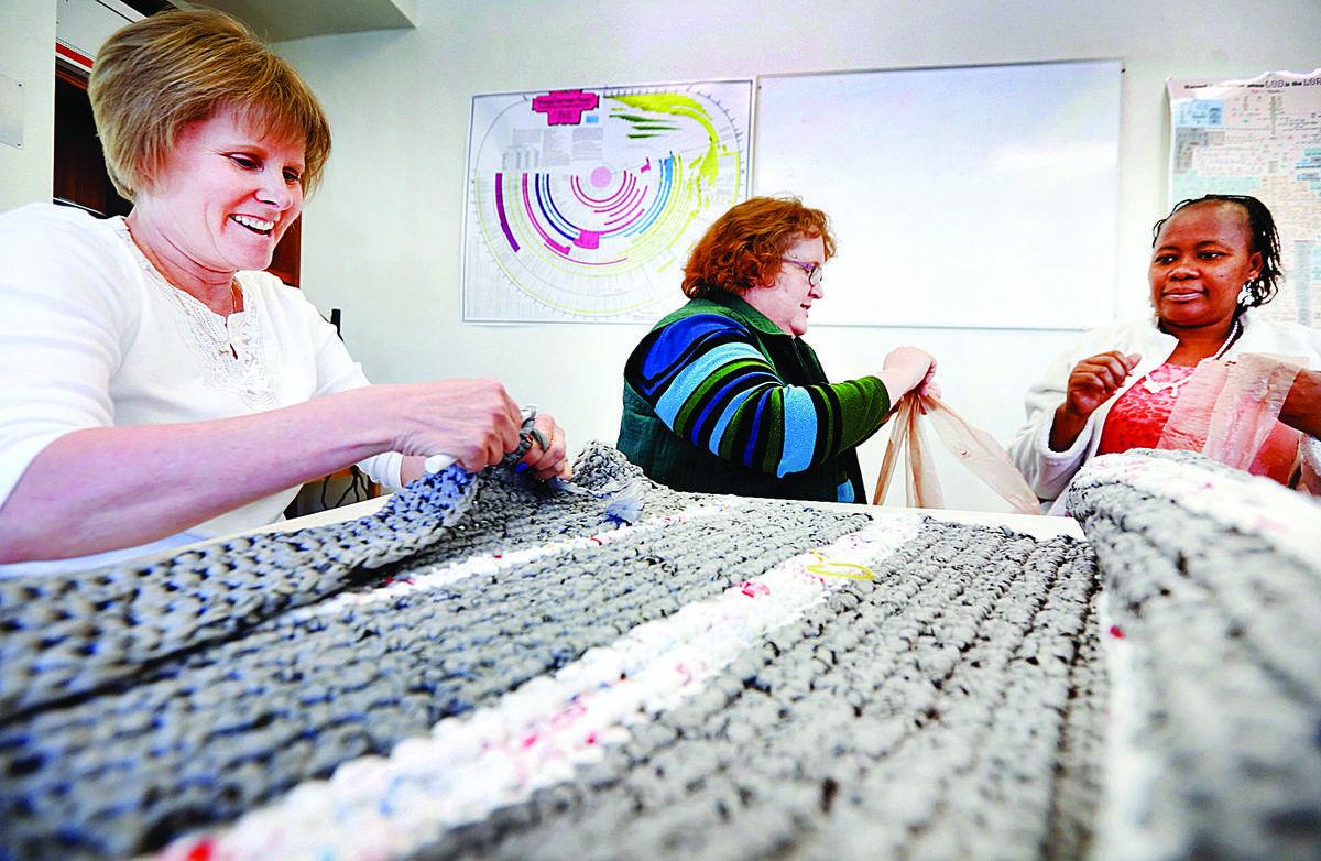 Church volunteers turn plastic grocery bags into sleeping mats for the