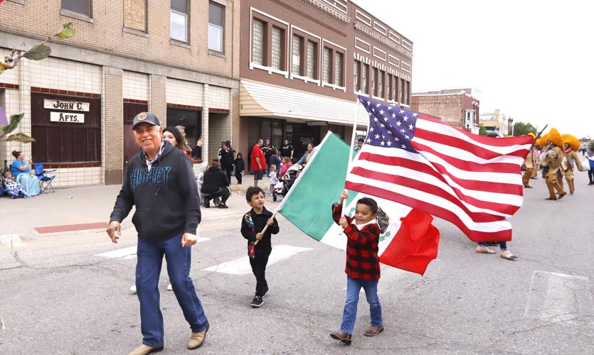 Man with flag-carrying children in parade